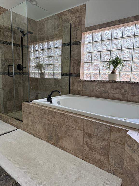 bathroom featuring a shower stall and a garden tub