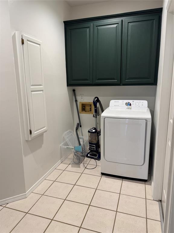 laundry room featuring light tile patterned floors, baseboards, cabinet space, and washer / dryer