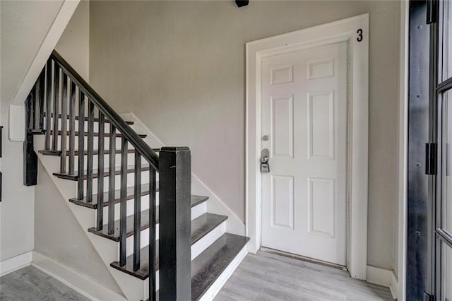 stairway with baseboards and wood finished floors