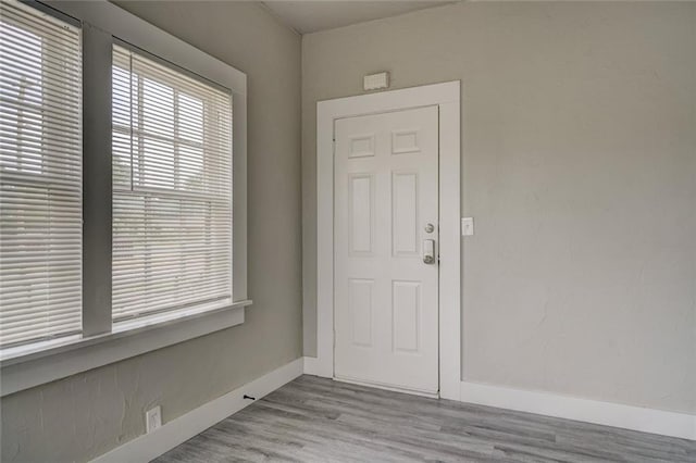 foyer with baseboards and wood finished floors