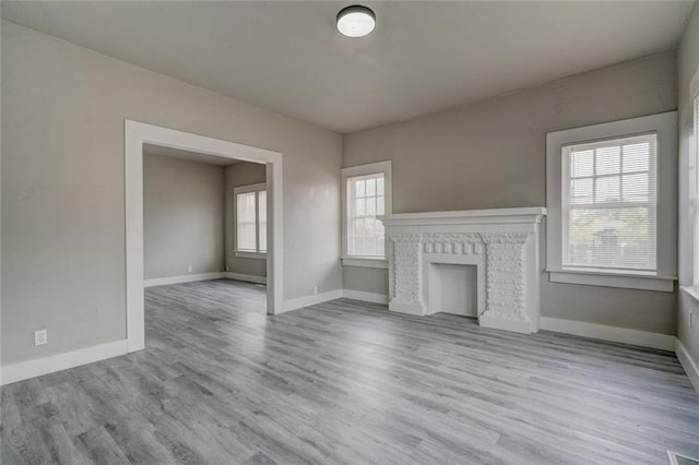324 NW 24th St, Oklahoma City, OK 73103 - unfurnished living room featuring a fireplace, wood finished floors, and baseboards