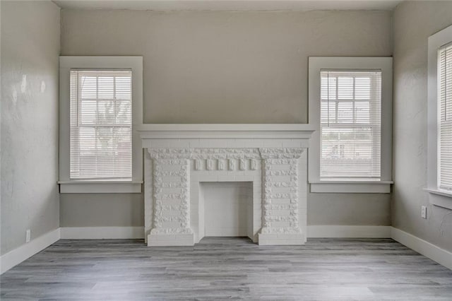 324 NW 24th St, Oklahoma City, OK 73103 - unfurnished living room featuring a fireplace, baseboards, and wood finished floors