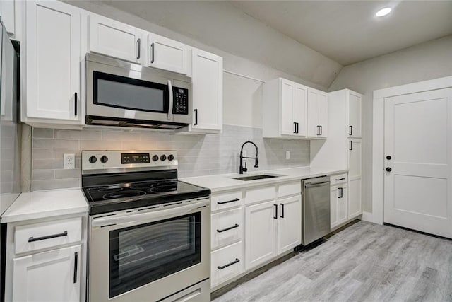 324 NW 24th St, Oklahoma City, OK 73103 - kitchen with light wood finished floors, light countertops, white cabinets, stainless steel appliances, and a sink