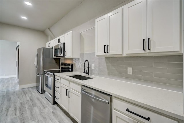 324 NW 24th St, Oklahoma City, OK 73103 - kitchen featuring decorative backsplash, white cabinets, appliances with stainless steel finishes, and a sink