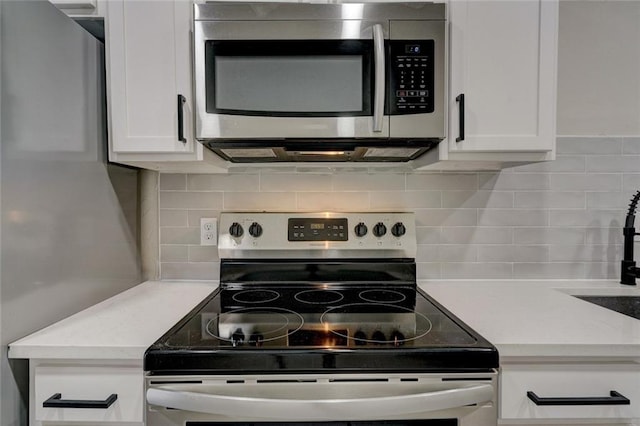 324 NW 24th St, Oklahoma City, OK 73103 - kitchen with decorative backsplash, white cabinets, and stainless steel appliances