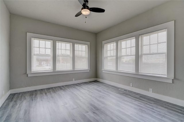 324 NW 24th St, Oklahoma City, OK 73103 - unfurnished room with a ceiling fan, visible vents, wood finished floors, and baseboards
