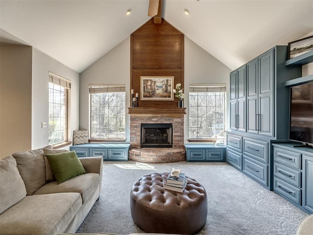 carpeted living area with a brick fireplace, beamed ceiling, and high vaulted ceiling