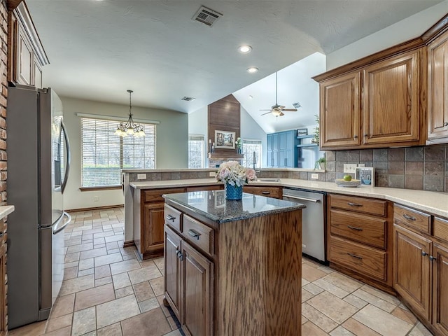 kitchen with backsplash, a kitchen island, stainless steel appliances, a peninsula, and lofted ceiling