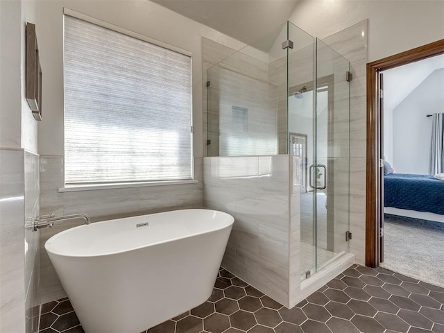 full bath featuring tile walls, a soaking tub, a shower stall, and ensuite bathroom