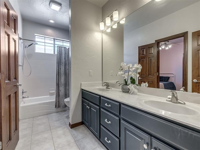 ensuite bathroom featuring a sink, toilet, double vanity, and tile patterned floors