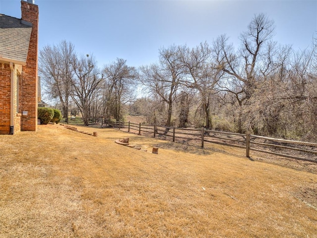 view of yard with a rural view and fence