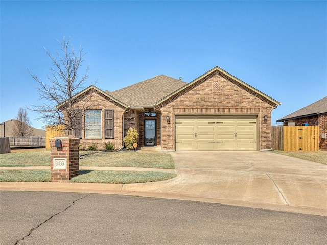 single story home with brick siding, an attached garage, concrete driveway, and fence