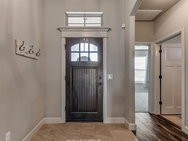 entryway with arched walkways, visible vents, and baseboards