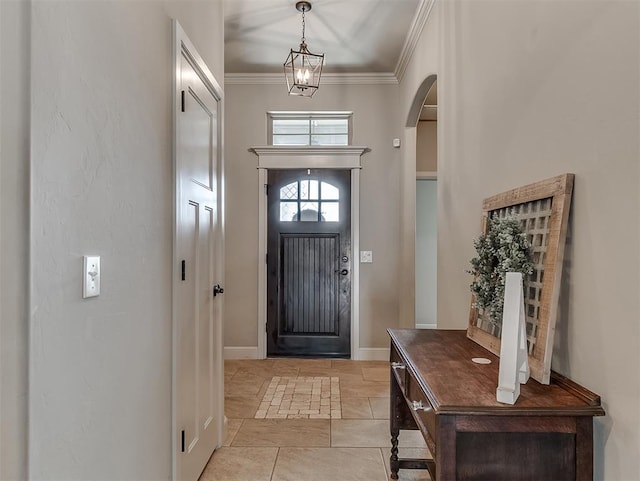 foyer with light tile patterned floors, baseboards, arched walkways, and ornamental molding