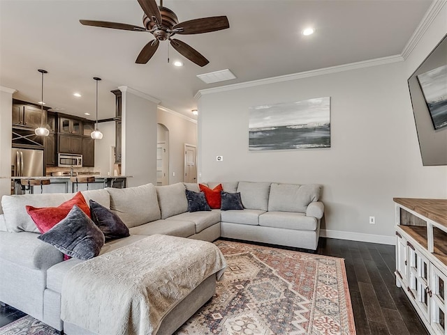 living area with crown molding, baseboards, dark wood-style floors, recessed lighting, and arched walkways