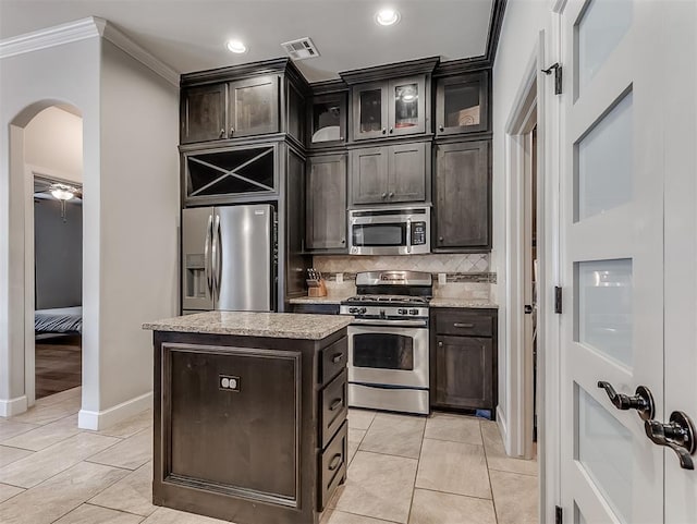 kitchen with visible vents, arched walkways, appliances with stainless steel finishes, and light tile patterned flooring