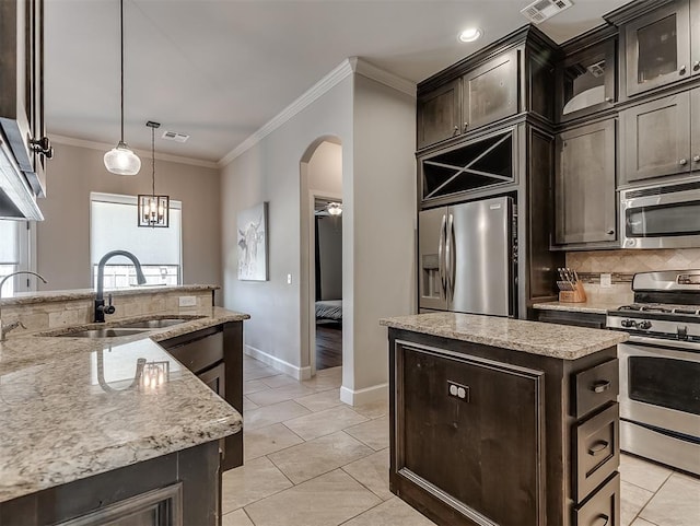 kitchen featuring visible vents, a sink, a center island, appliances with stainless steel finishes, and crown molding