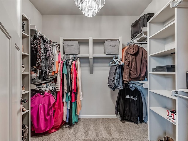 walk in closet featuring a notable chandelier and carpet