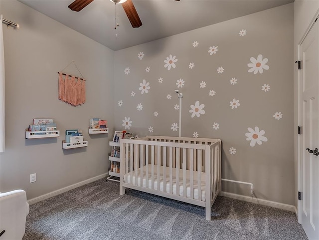 carpeted bedroom featuring ceiling fan, a crib, and baseboards