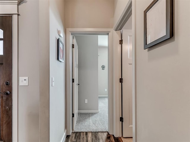 corridor with wood finished floors and baseboards