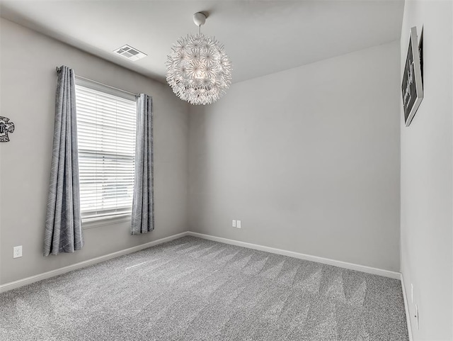 carpeted spare room featuring a chandelier, visible vents, and baseboards