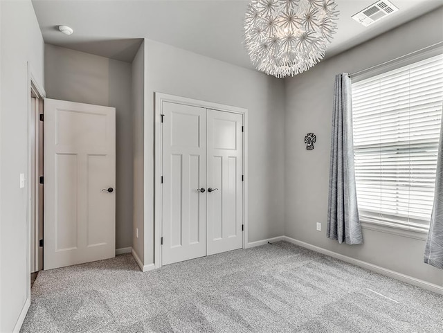 unfurnished bedroom featuring visible vents, baseboards, a closet, and carpet flooring