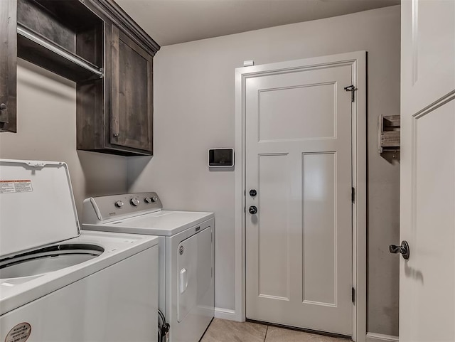 laundry room featuring cabinet space, light tile patterned floors, and washing machine and dryer