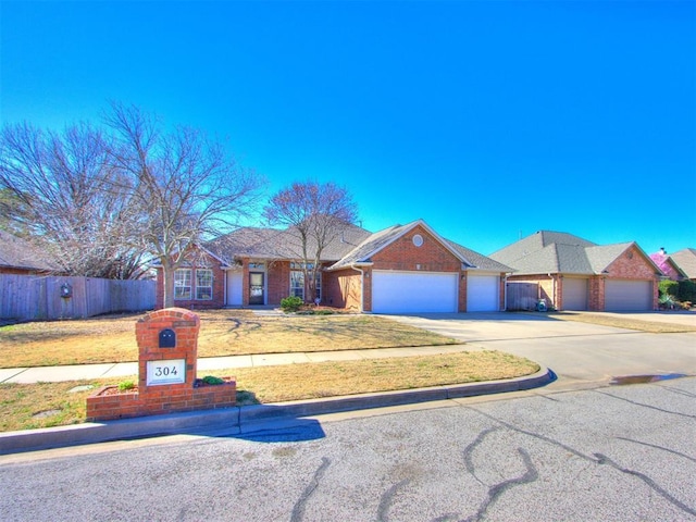 single story home featuring brick siding, an attached garage, driveway, and fence