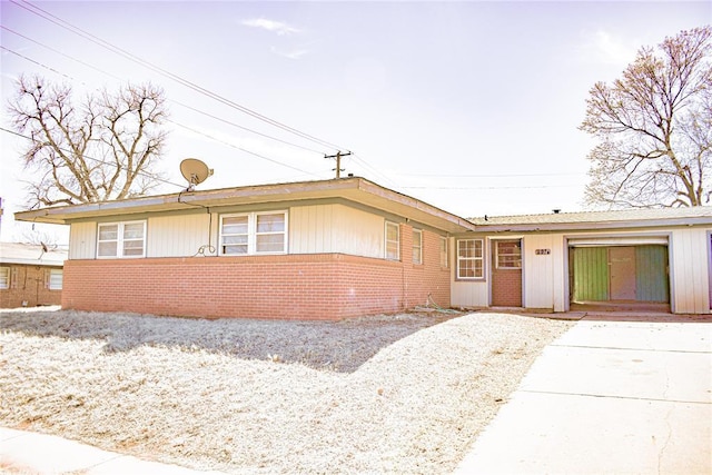 single story home featuring a garage, brick siding, and concrete driveway