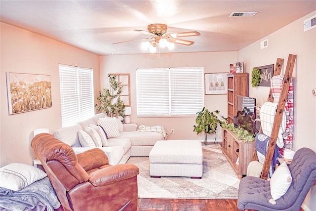 living room featuring wood finished floors, visible vents, and ceiling fan