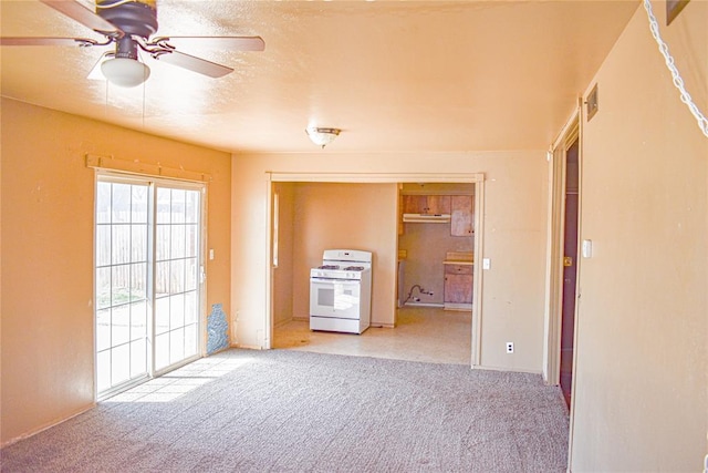 carpeted spare room featuring visible vents, a textured ceiling, and ceiling fan