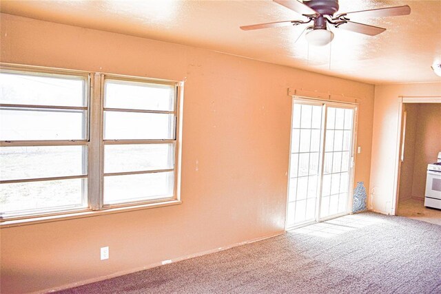 spare room with light carpet, a healthy amount of sunlight, a textured ceiling, and ceiling fan