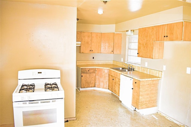 kitchen featuring white appliances, light floors, light brown cabinets, a sink, and light countertops