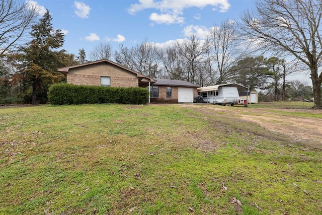 ranch-style house with brick siding, a garage, driveway, and a front yard