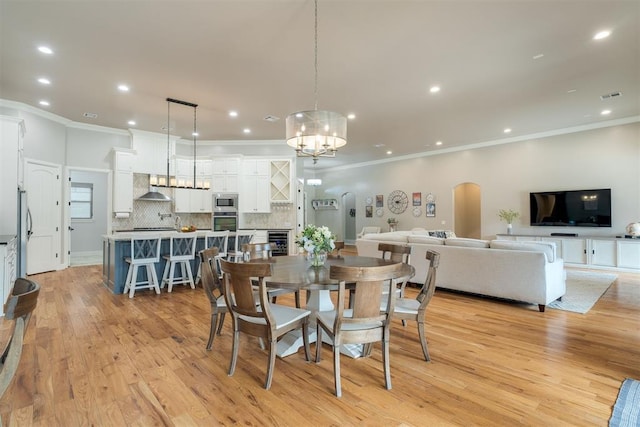 dining area featuring visible vents, recessed lighting, wine cooler, arched walkways, and light wood finished floors