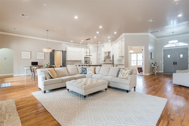 living room with visible vents, light wood-type flooring, and baseboards