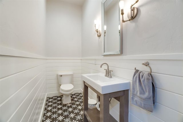 bathroom featuring wainscoting and toilet