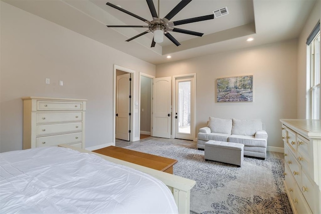 bedroom with a tray ceiling, visible vents, baseboards, and recessed lighting