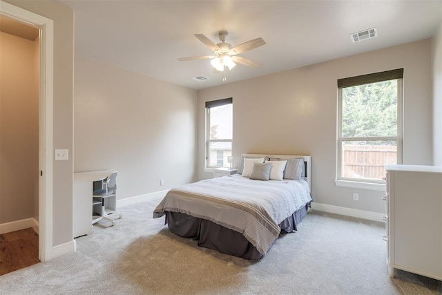 carpeted bedroom with visible vents, ceiling fan, and baseboards