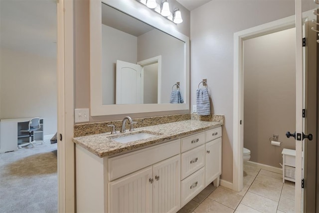 bathroom featuring tile patterned floors, baseboards, toilet, and vanity