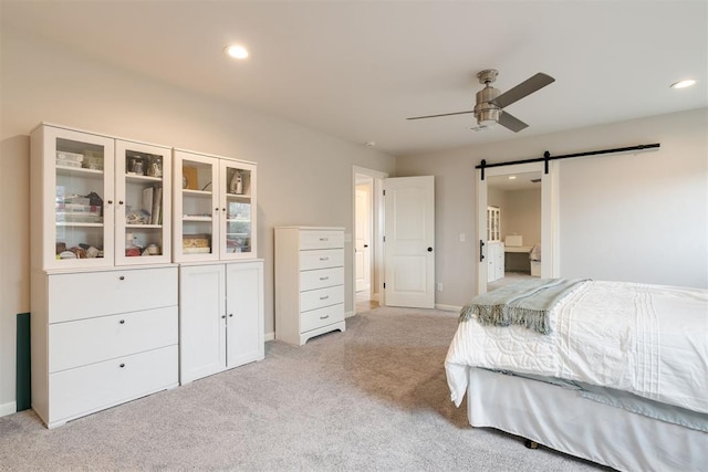 bedroom with recessed lighting, a barn door, baseboards, light colored carpet, and ceiling fan