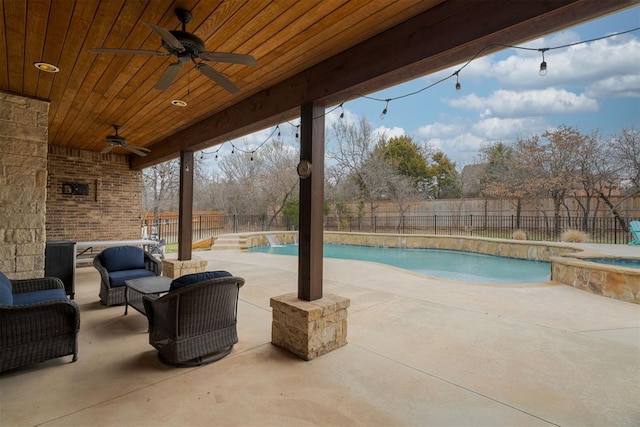 view of swimming pool with a patio, a fenced backyard, a pool with connected hot tub, ceiling fan, and outdoor lounge area