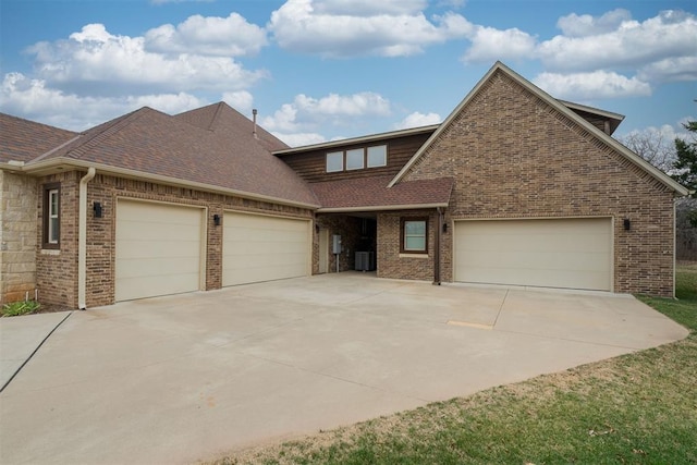 view of front of house featuring brick siding, concrete driveway, and an attached garage