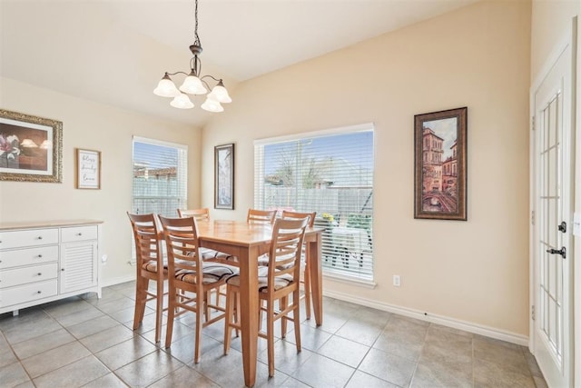 dining space featuring vaulted ceiling, light tile patterned flooring, baseboards, and a chandelier