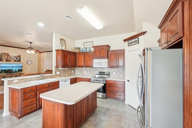 kitchen with visible vents, a sink, stainless steel appliances, light countertops, and tasteful backsplash