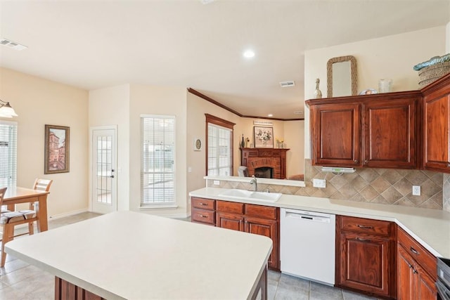 kitchen featuring visible vents, a sink, light countertops, dishwasher, and backsplash