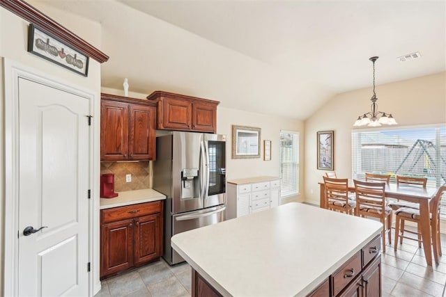 kitchen with light countertops, plenty of natural light, visible vents, and stainless steel refrigerator with ice dispenser