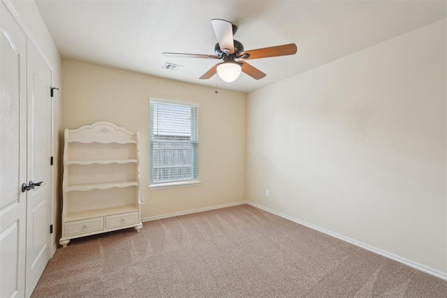 unfurnished bedroom featuring visible vents, a closet, carpet floors, baseboards, and ceiling fan