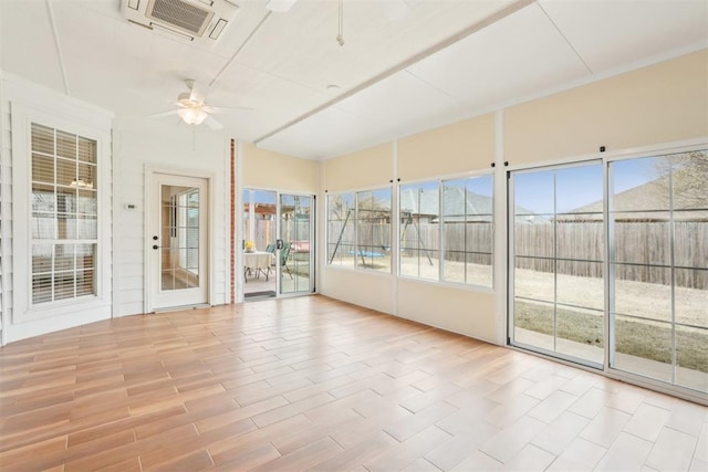 unfurnished sunroom featuring visible vents and ceiling fan