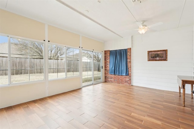 unfurnished sunroom featuring a ceiling fan